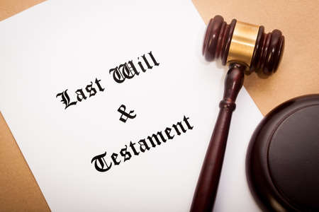 A gavel and soundboard on top of a "Last Will and Testament" contract, with a antique-like background.の写真素材