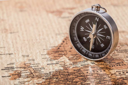 A photograph with shallow depth of field of a black compass on a map, with selective focus の写真素材