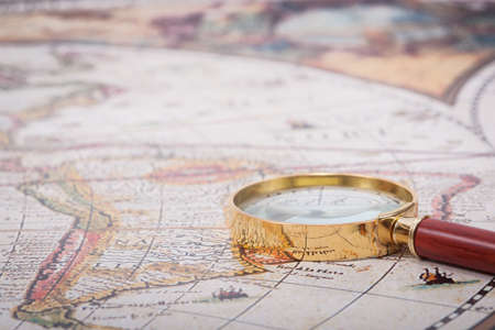 A beautiful antique map with an old magnifying glass with golden details.の写真素材