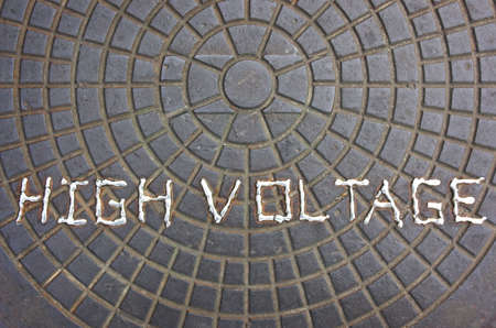 High voltage warning sign welded onto a manhole cover.の写真素材