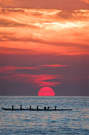 Hawaiian canoe coming home at sunsetの写真素材