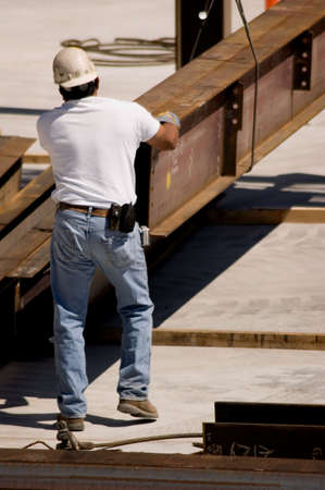 A construction worker handling an iron beamの写真素材