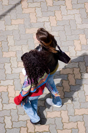 Two schoolgirls walking home on a sunny winter afternoon.の写真素材