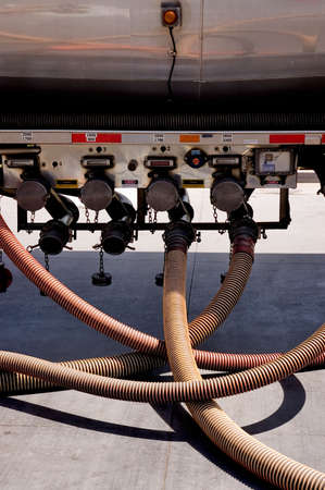 A tangle of hoses coming from a gasoline tanker truck.の写真素材