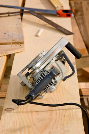 A workman's circular saw and other tools sitting on a piece of lumber