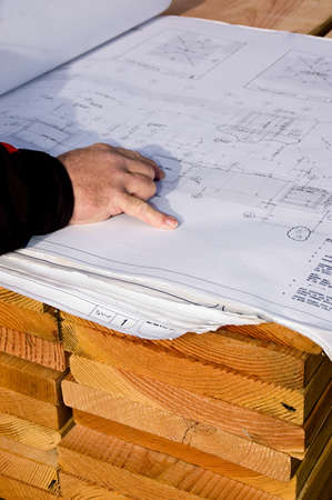 An architect at the job site, checking the project planの写真素材