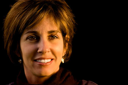 A smiling woman against a black background