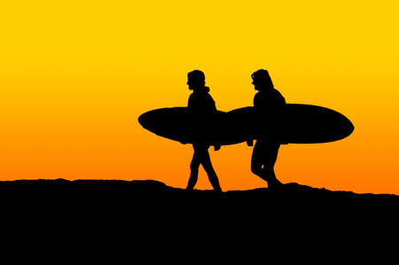 Two men carrying their surfboards and walking toward the oceanの写真素材