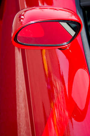 Closeup of the side view mirror on a red sports carの写真素材