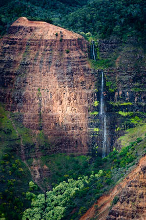 A sunlit waterfall on the island of Kauai.の写真素材