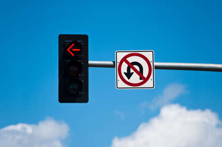 A left turn lane signal light and no u-turn sign.の写真素材