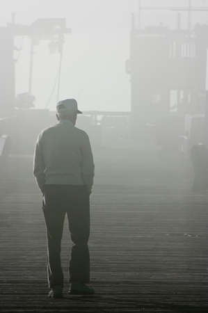 An old man walking into the fogの写真素材