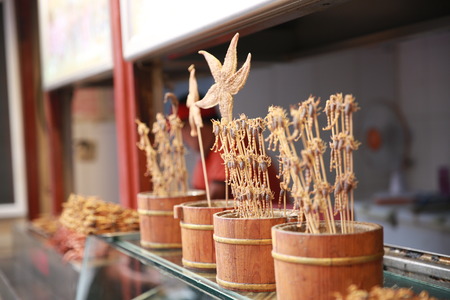 Close up to grilled scorpion and roasted starfish selling at the roadsideの写真素材