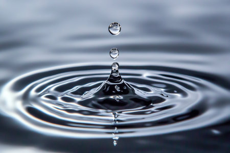 Water drop close-up. Splash effect after collision a falling drops with water Surfaceの写真素材