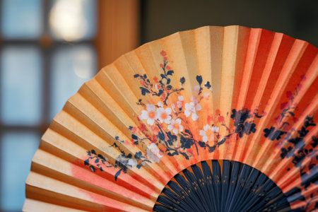 Japanese paper fan with floral pattern, close-up of hand fan