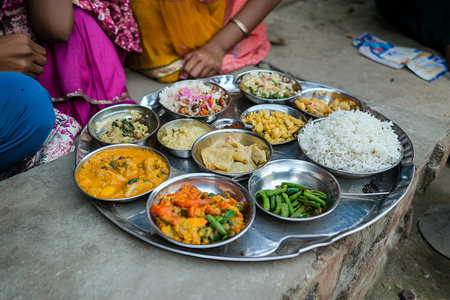 Traditional Indian food in a metal tray on the street.