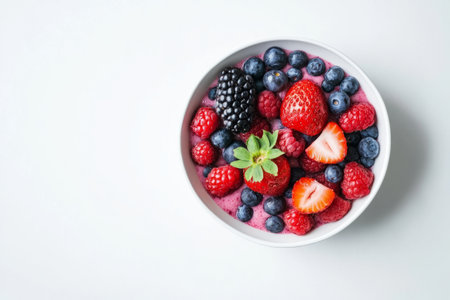 Fresh berries in a bowl on a white background, top view, copy spaceの写真素材