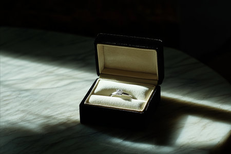 wedding ring in a box on a marble table with shadow