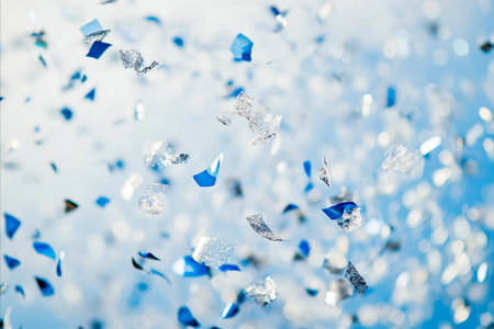 A vibrant image capturing a flurry of blue and silver confetti, creating a festive and celebratory atmosphere. The confetti is scattered against a soft, blurred background, suggesting movement and joy.の写真素材