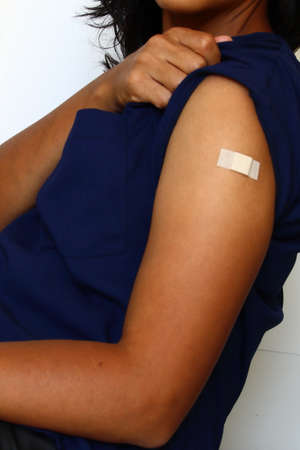 Patient with adhesive bandage on her arm after receiving a vaccine