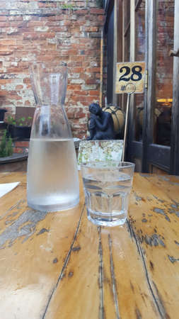 Iced water in a glass and a jug on a wooden tableの写真素材