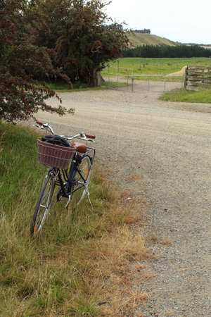 A bicycle parked on a country road in the middle of the countryside.の写真素材