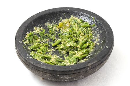 Sambal ijo or traditional green chili sauce from Indonesia, freshly made using stone mortar and pestle, isolated on white backgroundの写真素材