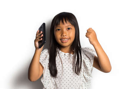 Happy asian little girl using smart phone on white background