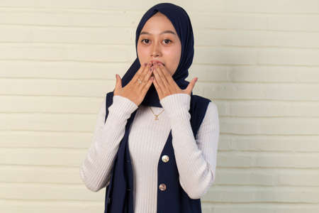 Young asian woman wearing hijab over isolated yellow background shocked covering mouth with hands...