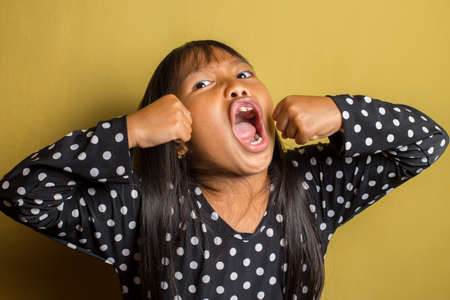 Asian little girl with punching fist to fight, aggressive and angry attack