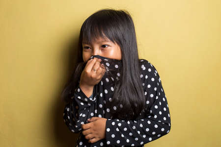 Asian little girl holding her nose because of a bad smellの写真素材