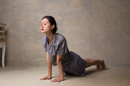 Portrait of gorgeous young asian woman practicing yoga indoor. Beautiful girl practice cobra asana...