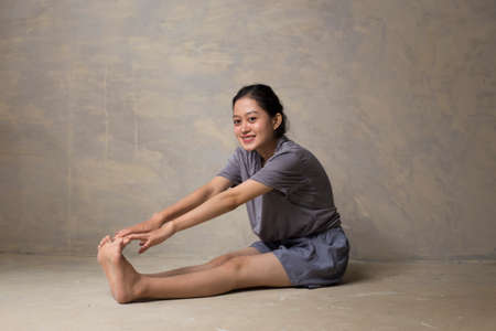 Portrait of fit and sporty young asian woman doing stretchingの写真素材