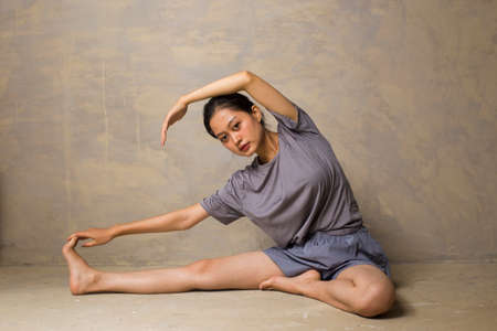 Portrait of fit and sporty young asian woman doing stretchingの写真素材