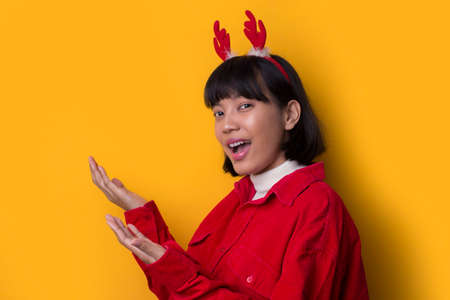 Portrait beautiful asian women wear santa christmas hat with hand point on empty spaceの写真素材