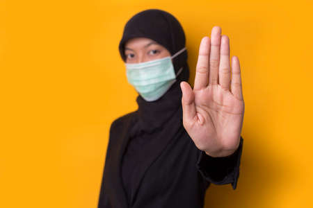 Pretty and confident muslim young asian business woman with medical protective face mask to protect...