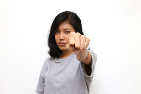 Portrait of asian young woman looking at camera ready to fight, fist close upの写真素材