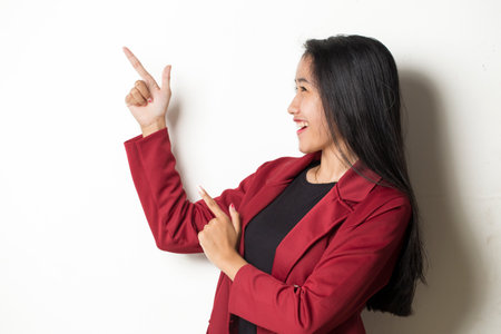 Young asian business woman on white background smiling confident pointing with fingers to different directions. Copy space for advertisementの写真素材