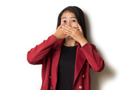 Asian woman put her hand close (cover) her mouth feeling surprise to somethingの写真素材