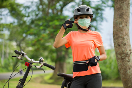 Beautiful asian woman cyclist wearing face maskの写真素材