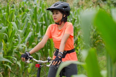 portrait of young asian woman cyclist with bikeの写真素材