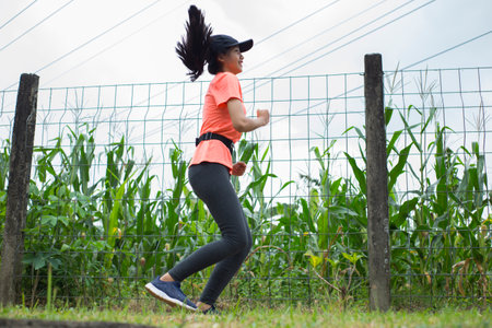 A portrait of a young asian woman doing excercise outdoor in a park, joggingの写真素材