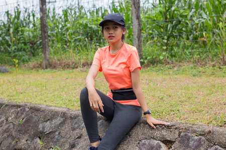 beautiful young asian sports woman sitting outdoors