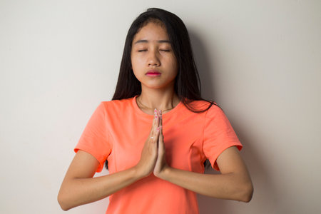 Asian woman do yoga practice meditating indoors, lotus position. No stress, mindfulness, inner balance conceptの写真素材