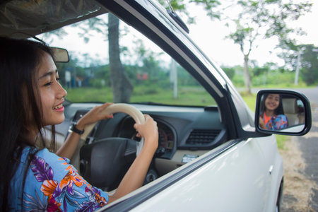 portrait of young asian woman driving a carの写真素材