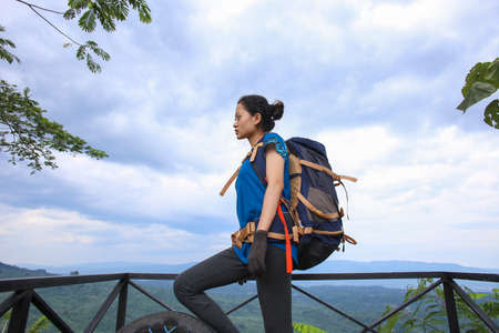 Successful asian woman hiker enjoy the view on mountain top