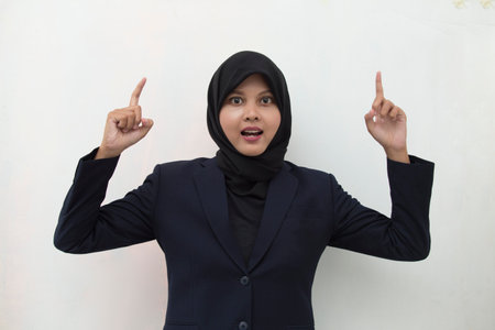 Young asian business woman wearing hijab smiling confident pointing with fingers to different directions. Copy space for advertisementの写真素材