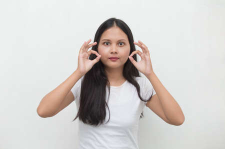 Young asian woman smiling and making OK sign with hand gesture.の写真素材