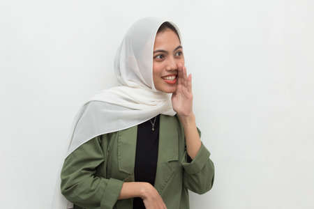 Portrait of young Asian muslim woman announcement shouting and yelling