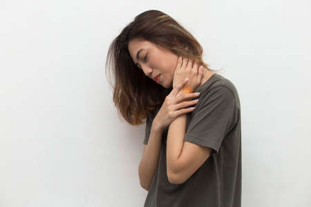 portrait of a beautiful asian young woman with sore throat neck and shoulder pain, isolated on a white backgroundの写真素材